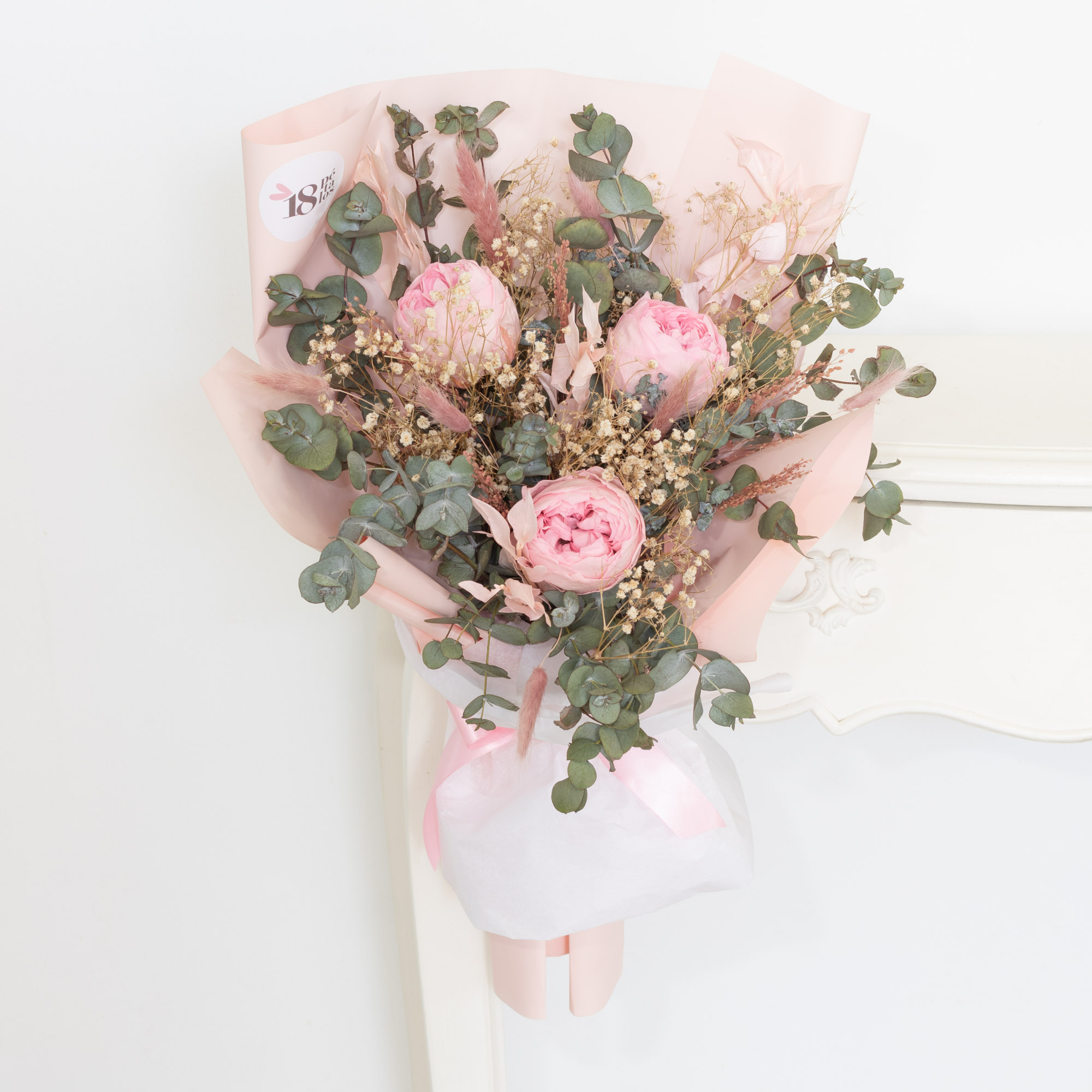 Ramo de peonías preservadas rosa vintage con follaje verde y estilo elegante