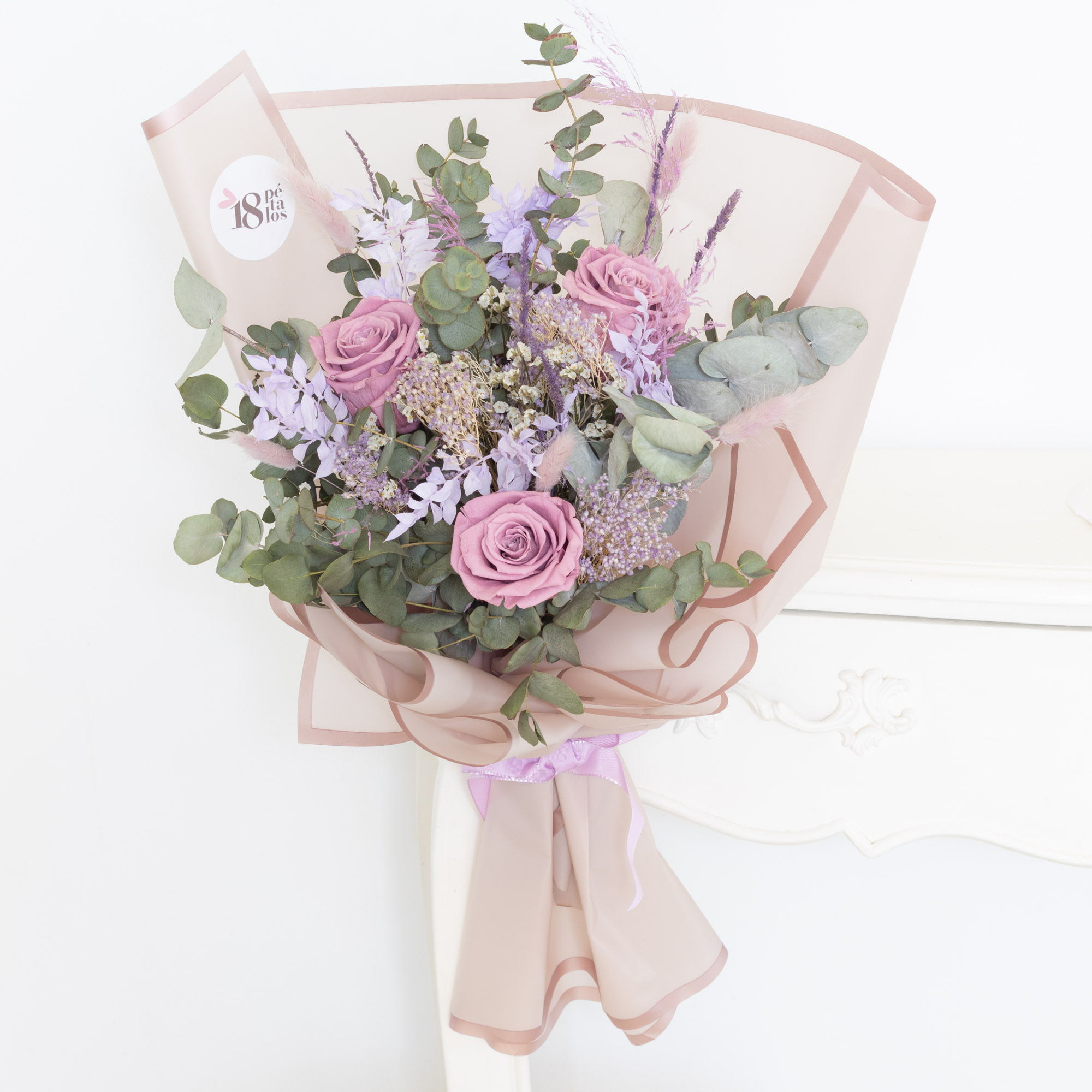 Ramo de rosas preservadas lila con follaje verde y estilo elegante