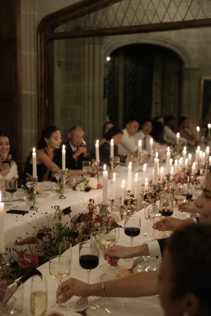 Mesa imperial de boda a la luz de velas con centros florales en burdeos, anthurium y bayas silvestres diseñados por 18 Pétalos en La Baronía